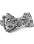 Light grey silk bow tie with all-over print of Bowdoin College seal.