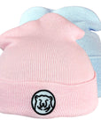 Montage of pink and blue baby hats.