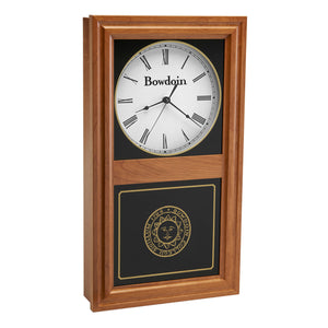 Autumn finish wall clock with clock face in upper inset in white with a Bowdoin wordmark and Roman numerals, and a Bowdoin College seal in gold on the lower glass.