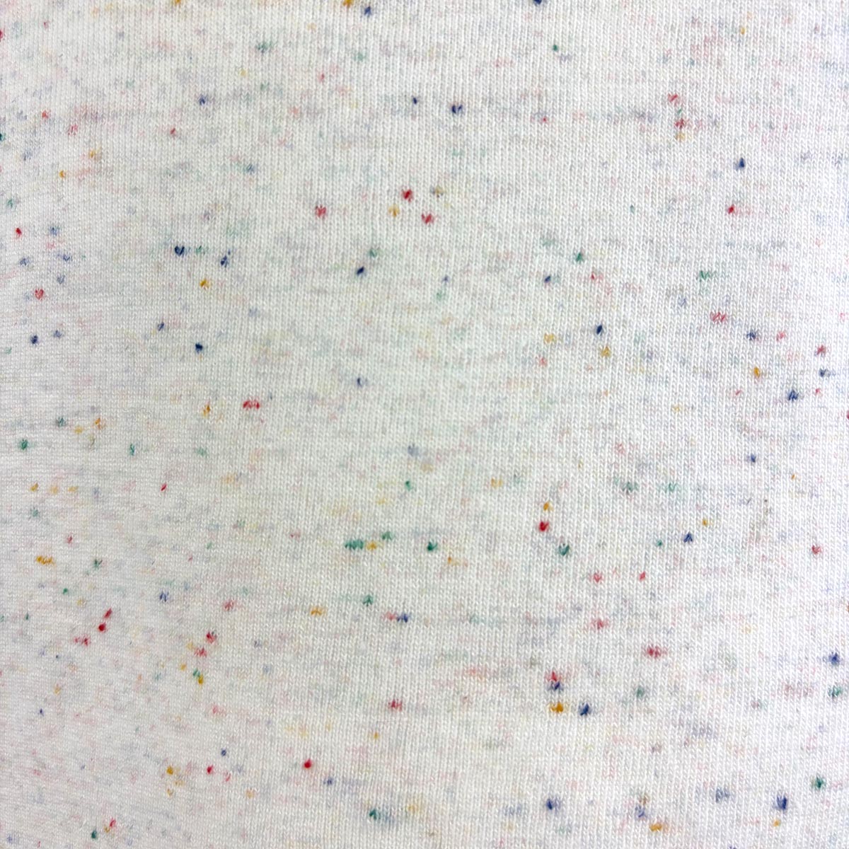 Closeup of white fabric with multicolored speckles