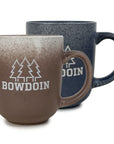 Two mugs, one brown and one gray, with pine trees and 'Bowdoin' branding on a white background.