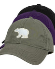 Three baseball caps in black, purple, and green with a polar bear emblem on a white background.