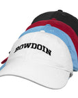 A stack of four baseball caps in black, red, light blue, and white, with the front white cap featuring the word 'BOWDOIN' embroidered in black arched lettering.
