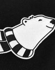 Detail of cartoon polar bear with a striped scarf applique on black fabric.
