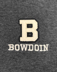 Close-up of a dark heather gray fabric with an embroidered cream letter B and the word BOWDOIN underneath.