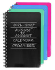 A set of spiral-bound 2026-2027 August to August calendar organizers stacked in a fan arrangement. The front organizer has a black chalkboard-style cover with white text, while the nested organizers behind it are in blue, mint green, and bright pink.