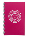 A pink spiral-bound notebook with a white printed circular emblem featuring a sun face and the text BOWDOIN COLLEGII SIGILLUM 1794', shown on a plain white background.