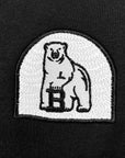 Closeup of arched white embroidered polar bear patch.
