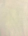 A close-up of a light cream or off-white textured fabric with subtle speckles and a fine woven pattern.