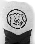 Closeup of white needlepoint headcover with mascot medallion.