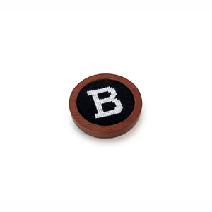 Small round wooden ball marker with needlepointed B in white on black decoration.