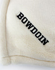 Closeup detail of black BOWDOIN embroidery in corner of cream white plush throw.
