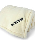 Cream white plush throw with black BOWDOIN embroidered in one corner.