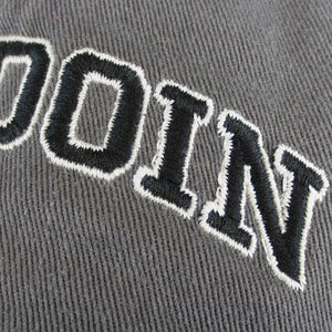 Closeup showing the high-quality embroidery of the letters OIN in black with a white outline.