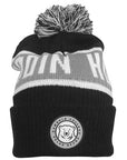Black knit hat with white and grey stripe, white BOWDOIN HOCKEY knit into grey stripe. Embroidered patch with mascot medallion surrounded by BOWDOIN COLLEGE POLAR BEARS on cuff.