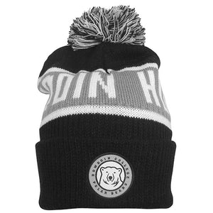 Black knit hat with white and grey stripe, white BOWDOIN HOCKEY knit into grey stripe. Embroidered patch with mascot medallion surrounded by BOWDOIN COLLEGE POLAR BEARS on cuff.
