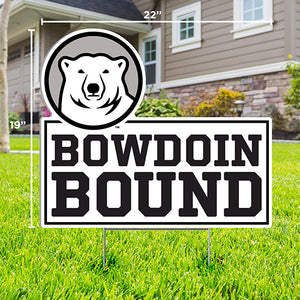 Lawn sign with cutout of mascot medallion over text BOWDOIN BOUND staked in a grassy lawn in front of a house.