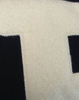 Closeup of ivory B applique on black sweatshirt.