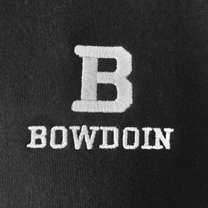 Closeup of black sweatshirt showing the high quality embroidery of the Bowdoin B embroidered over the word BOWDOIN in white.