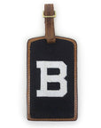 Brown leather luggage tag with brass buckle and needlepointed Bowdoin B backing.