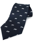 Rolled up navy blue necktie with white all-over woven imprint of polar bears in profile.