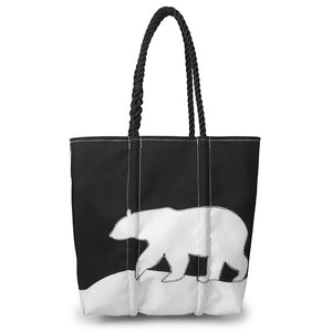 Black tote bag with black rope handle and white stitched applique polar bear silhouette design.
