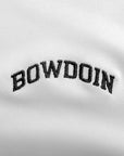 Closeup of black arched BOWDOIN embroidery on white polo shirt.
