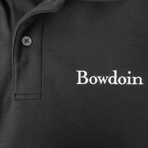 Closeup showing L.L.Bean branded button and white Bowdoin embroidery on polo shirt.