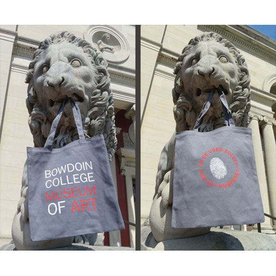 Two photos of a museum of art lion sculpture holding a grey tote bag in its mouth. One side of the bag reads BOWDOIN COLLEGE MUSEUM OF ART in white and red letters. The other side shows a white fingerprint surrounded by the phrase "To be used solely for art purposes" in red print.