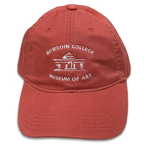 Light red ball cap with Bowdoin College Museum of Art logo embroidered in white on front.