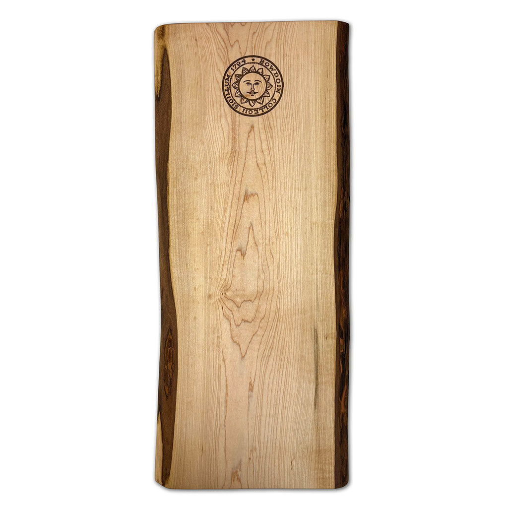 Wooden breadboard with laser engraved Bowdoin College seal at top end.