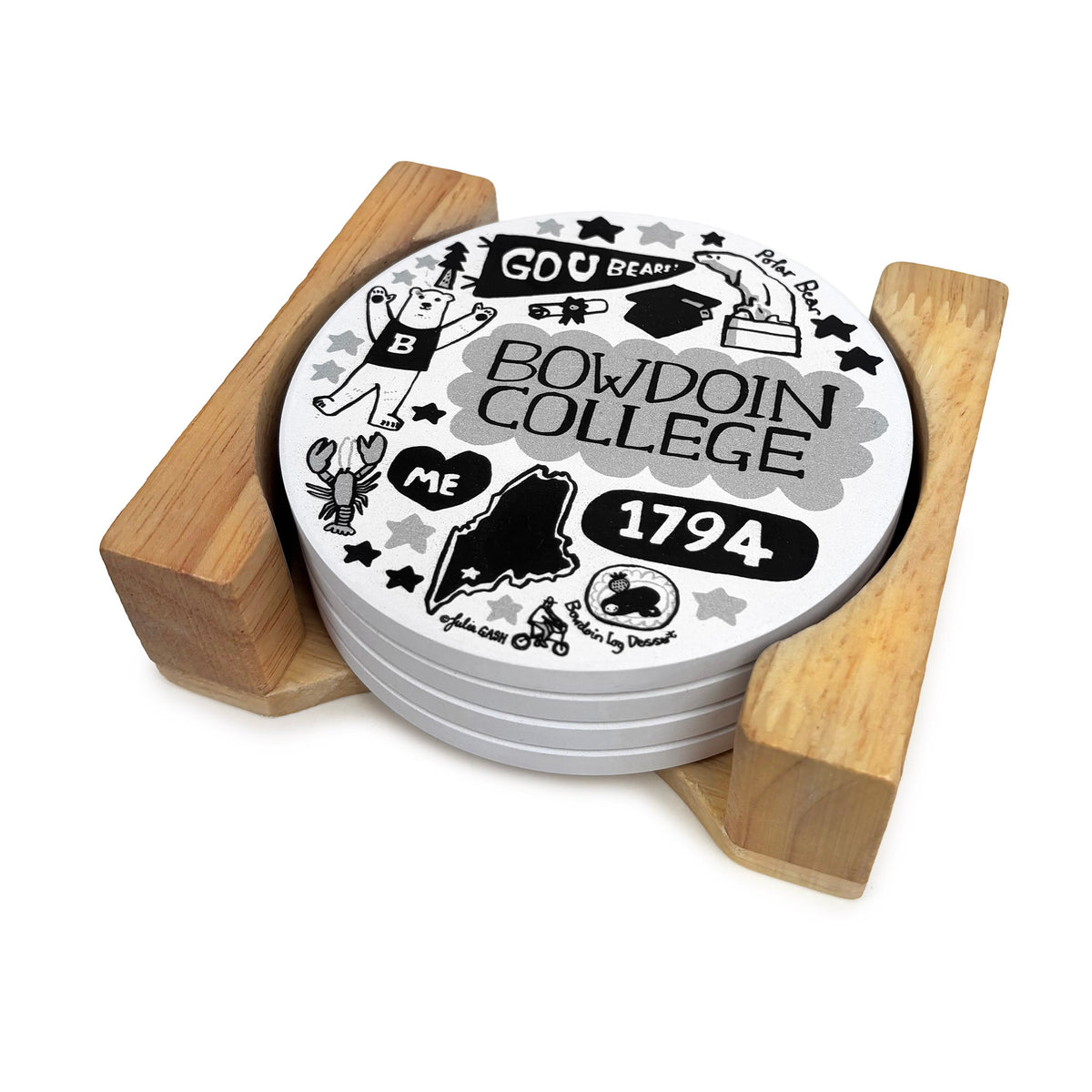 Four white round coasters in a wooden stand. The coasters are decorated with black and white cartoon illustrations of Bowdoin College icons like the polar bear, the Bowdoin log dessert, and a Go U Bears pennant.