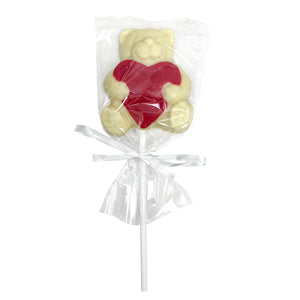 White chocolate lollipop in the shape of a teddy bear holding a red heart.