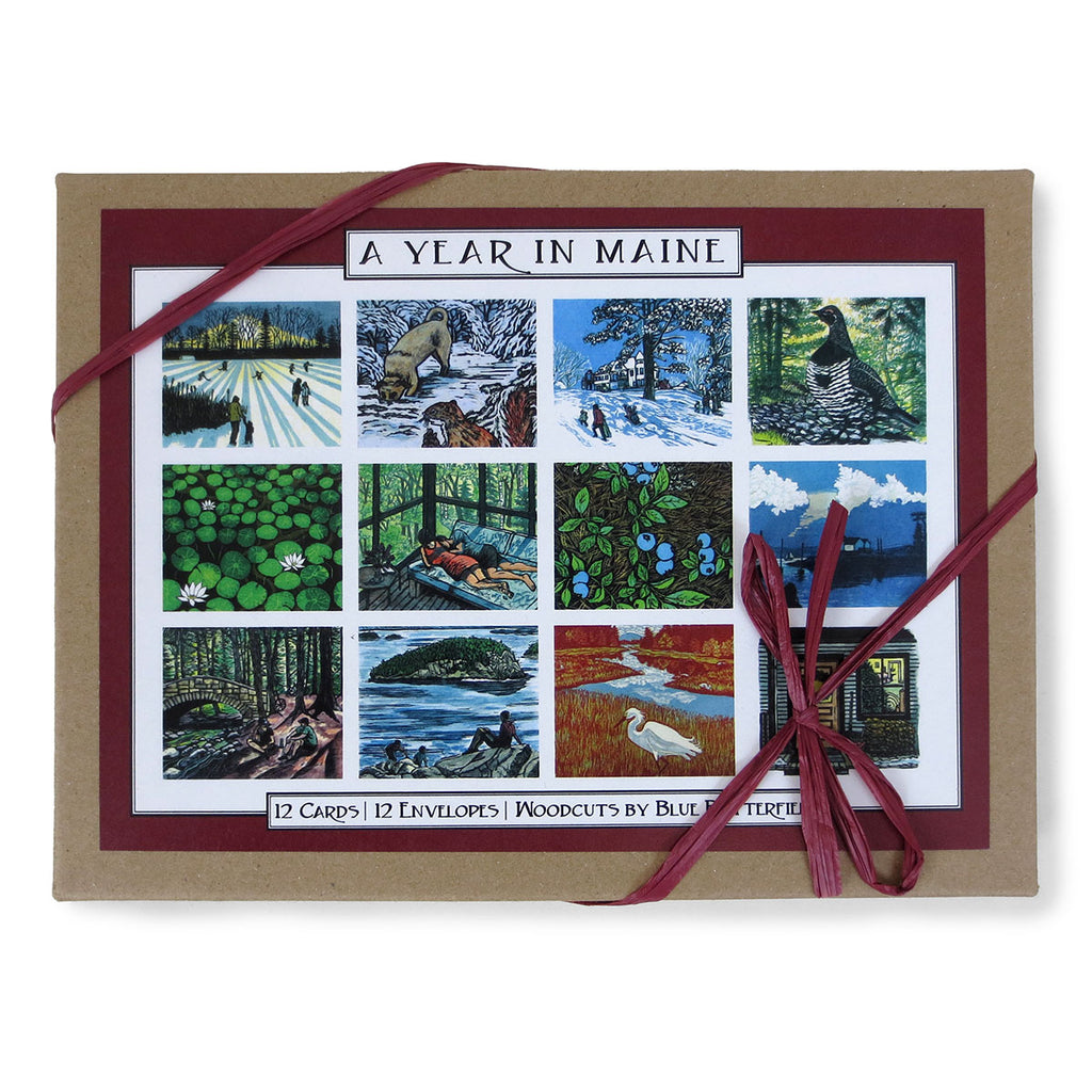 Craft paper box of cards with white paper ribbon featuring 12 designs of Maine scenes woodcuts.