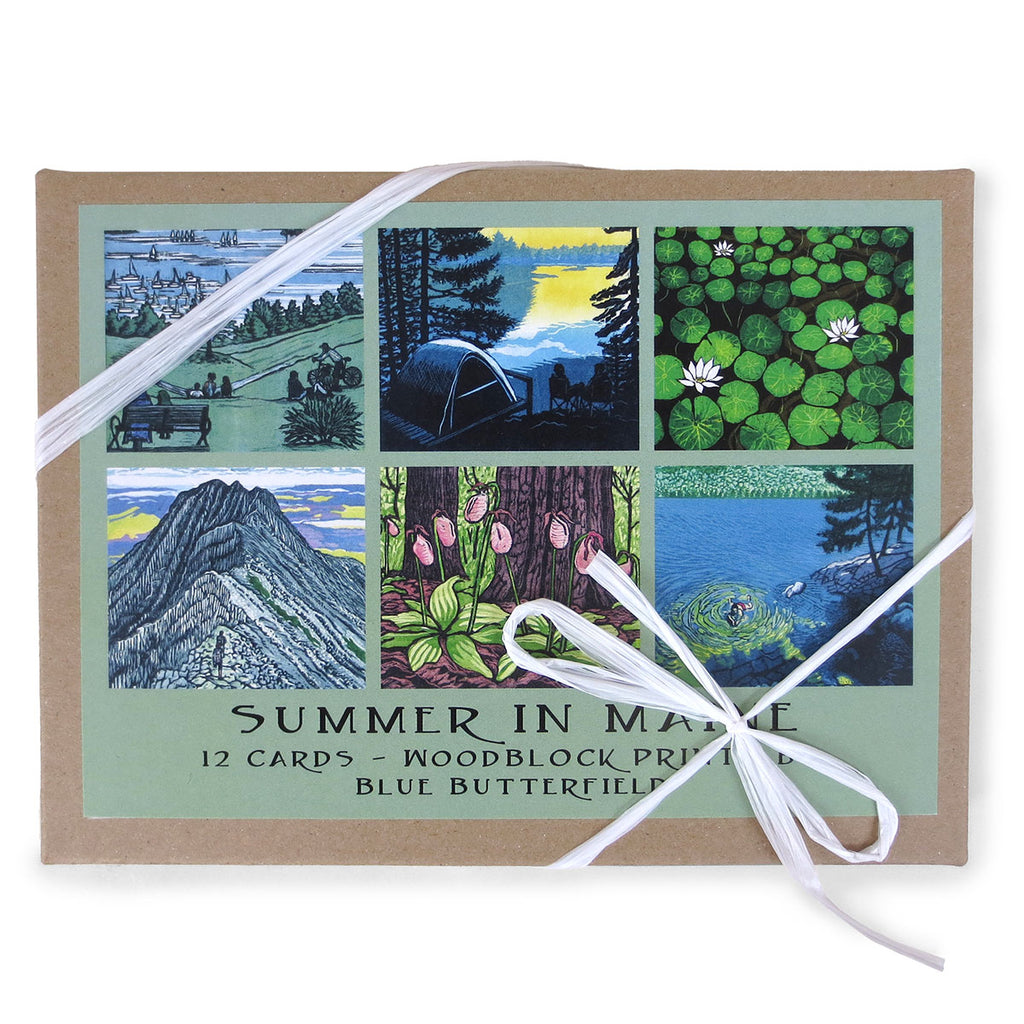 Craft paper box of cards with white paper ribbon featuring 6 designs of Maine summer woodcuts.