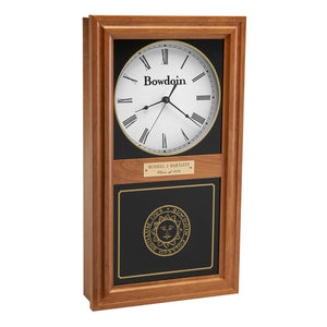 Autumn finish wall clock with clock face in upper inset in white with a Bowdoin wordmark and Roman numerals, and a Bowdoin College seal in gold on the lower glass. Optional brass engraved plaque is shown on midrail.