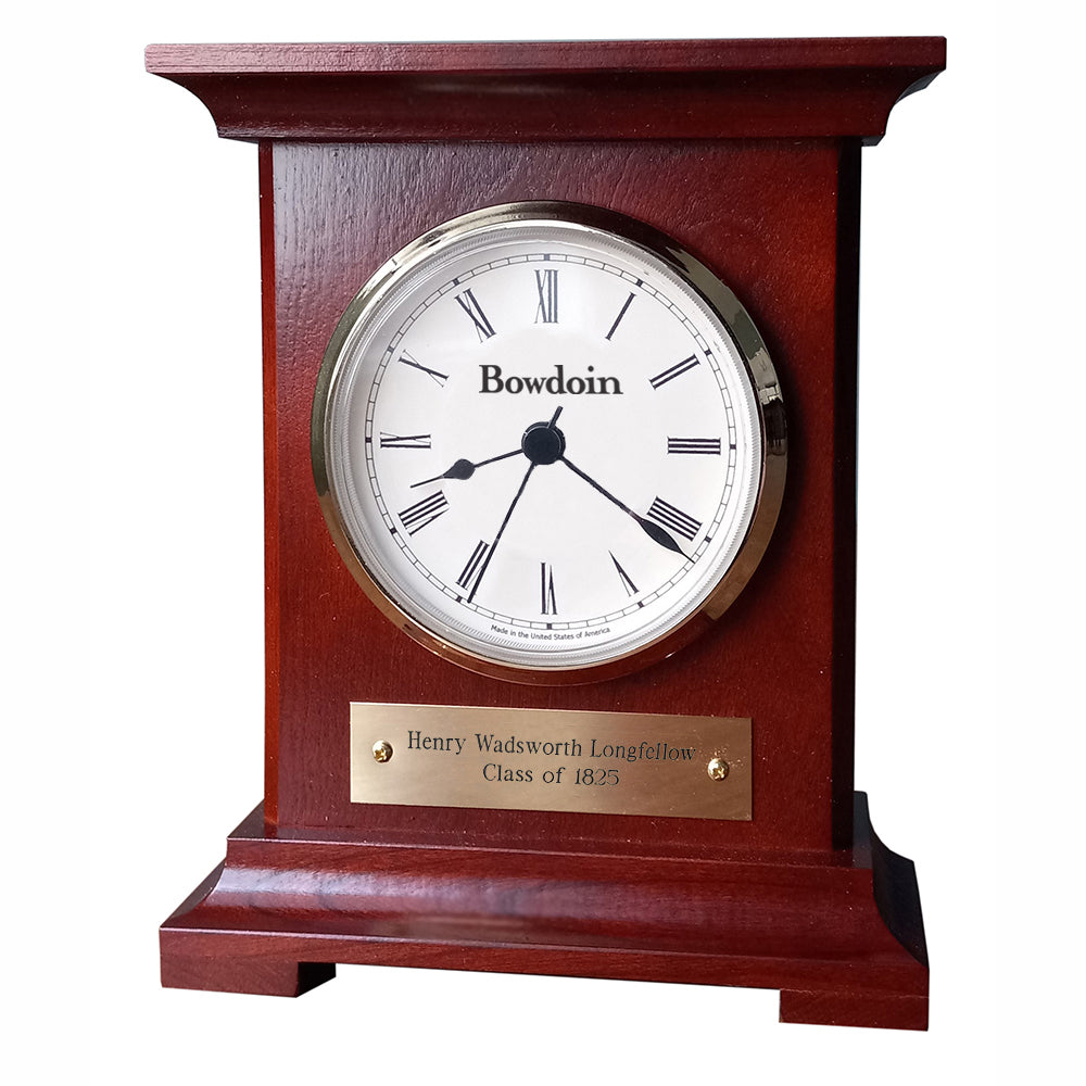 Burgundy finish wooden desk clock with white and brass dial, black Roman numerals, and BOWDOIN wordmark. Brass plaque showing personalization has Henry Wadsworth Longfellow Class of 1825 engraved on two lines.