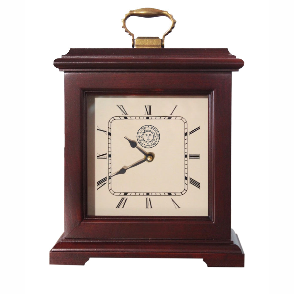 Burgundy finish clock with brass handle on top. Cream dial with Roman numerals, Bowdoin above hands, Bowdoin seal below hands. 