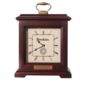 Burgundy finish clock with brass handle on top. Cream dial with Roman numerals, Bowdoin above hands, Bowdoin seal below hands. Plaque below dial with personalization: Henry Wadsworth Longfellow, Class of 1825