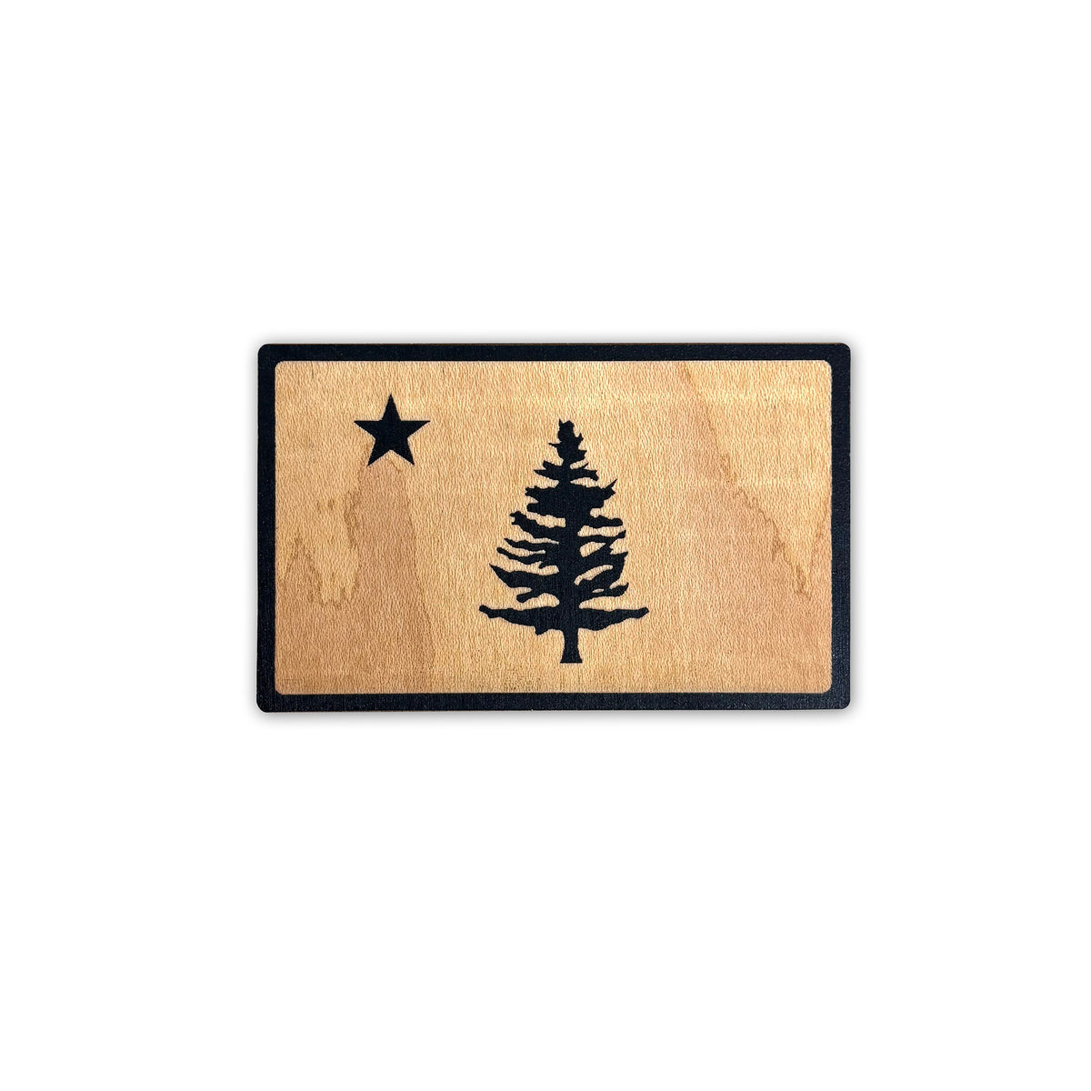 Wooden sticker with black border and black star and pine tree design, shown on a white background.