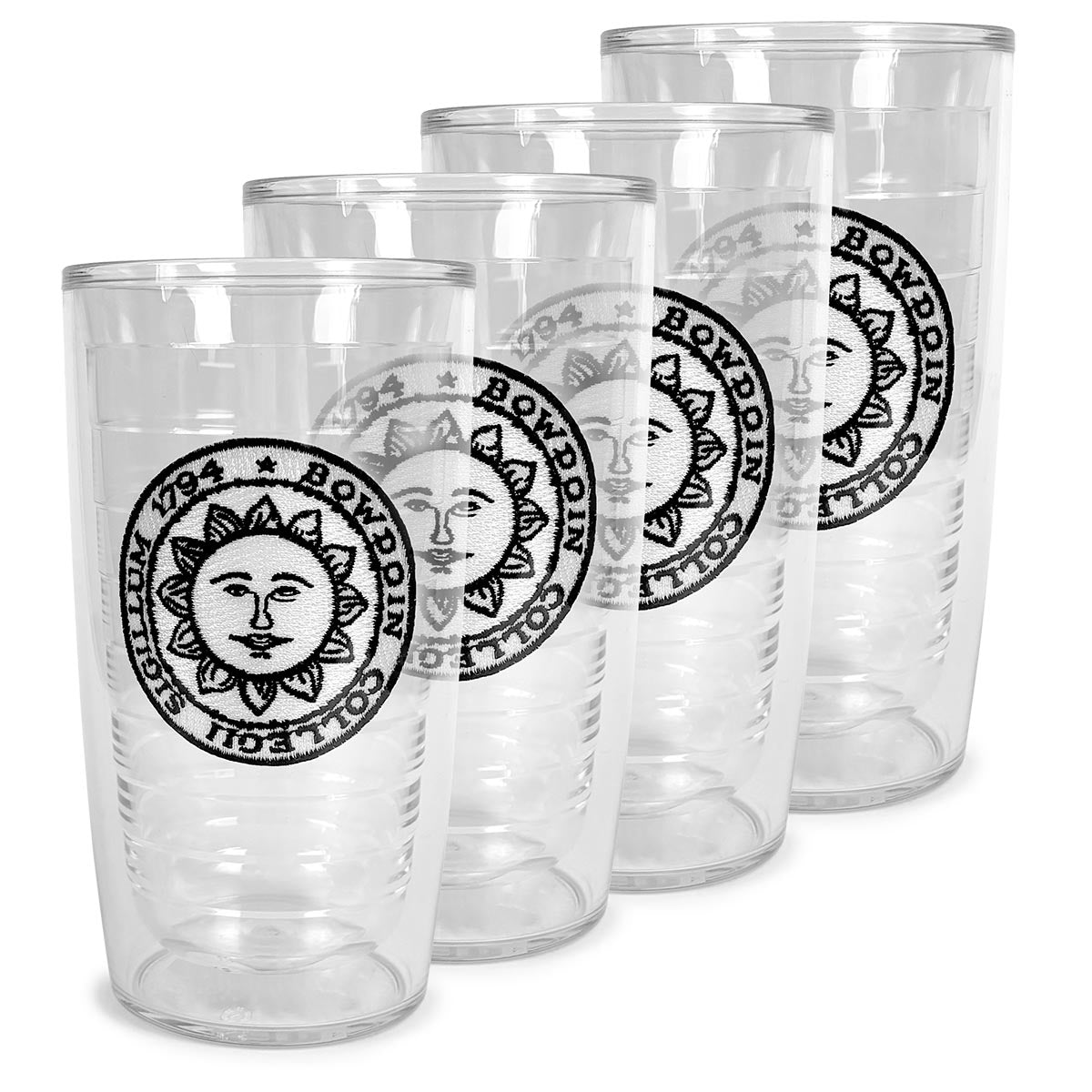 Set of four clear tumblers with Bowdoin College sun seal patches on a white background
