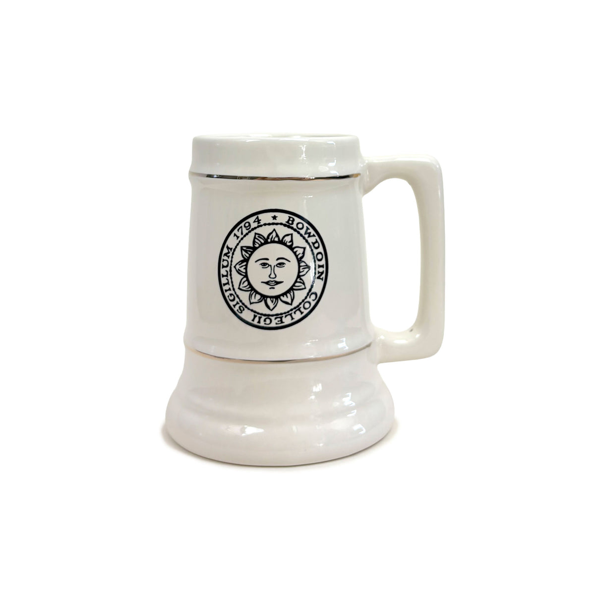 A white ceramic beer stein mug with a handle, featuring a black circular sun face logo on the front and a thin gold line detail near the rim, set against a plain white background.