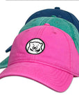 Pink, green, and navy baseball caps with polar bear logo on white background.