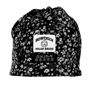 Black beanie with black and white floral print. Front and center is a white patch with BOWDOIN arched over a mascot medallion over POLAR BEARS over a black patch with SKIDA over five snowflakes.