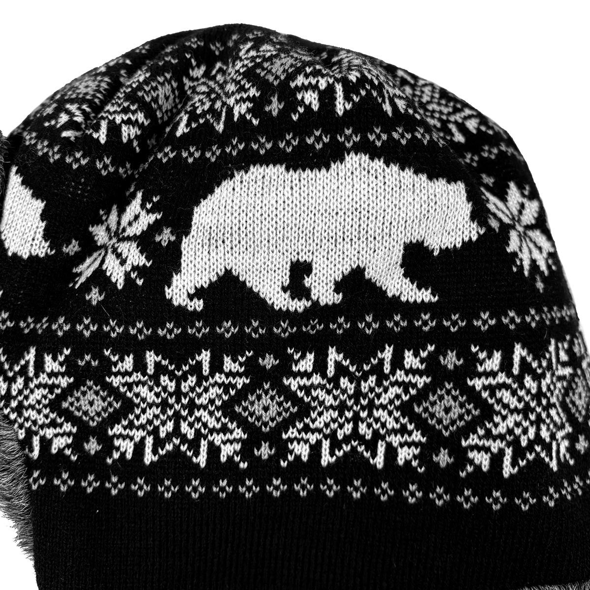 Knitted hat with black and white pattern featuring a bear and geometric shapes.