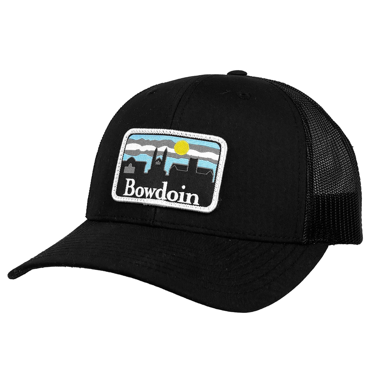 A black trucker hat with a curved brim and black mesh back panels, featuring a rectangular embroidered patch on the front with a building skyline, a yellow sun, and the word 'Bowdoin' in white text.