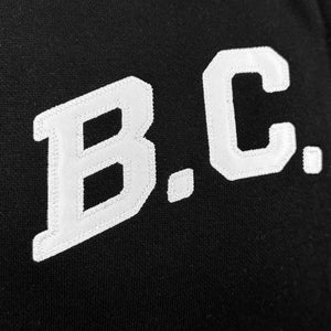 Closeup detail of B. C. white twill applique on black sweatshirt fleece.