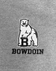 Close-up of a gray fabric surface featuring a white embroidered polar bear graphic with a black outlined letter B and the word BOWDOIN below it.