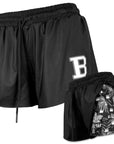 Two views of black shorts with a letter 'B' logo, one showing a liner with a black, white, and grey Hawaiian print with incorporated repeating B and paw print motif.