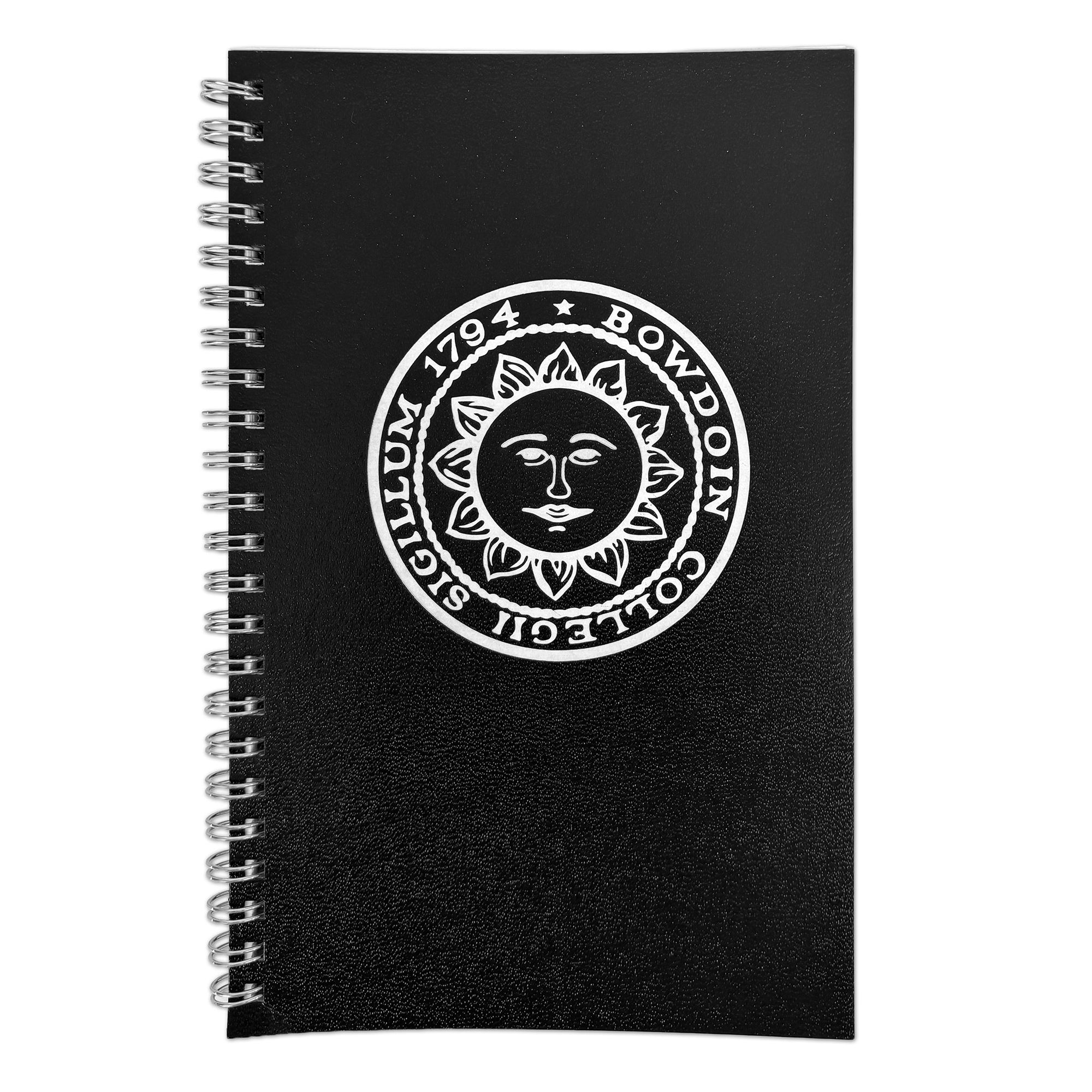 A black spiral-bound notebook with a white circular sun face emblem and the text 'BOWDOIN COLLEGII SIGILLUM 1794' printed on the cover, shown on a plain white background.